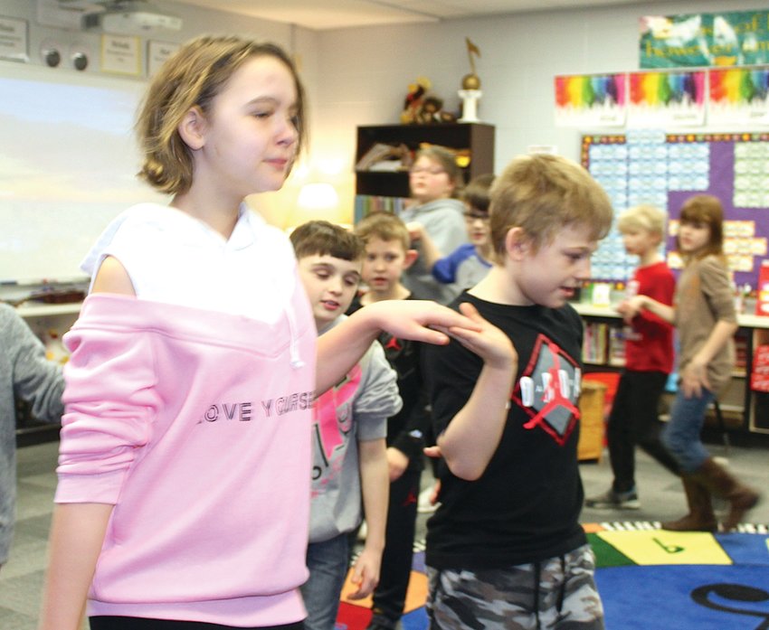 Ladoga Elementary fourth graders Kahlan Smith, left, and Josh Elliot learn a folk-style dance in Jennifer Ellingwood's music class on Thursday.