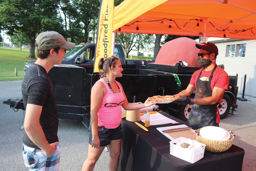 Waveland&rsquo;s David Cotten, left, and Laura Lee Noel have their order filled by Wildfire 348&rsquo;s Zach Green on Saturday at Milligan Park, which saw a fraction of attendants compared to previous years for Fourth of July celebrations.