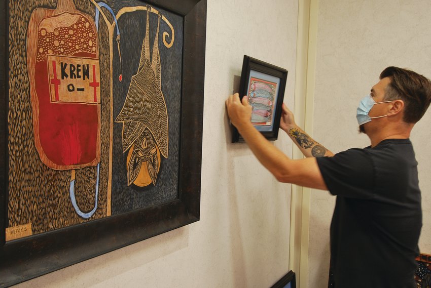 Matt Rees hangs a woodblock print while installing his art exhibit in the Mary Bishop Memorial Gallery at the Crawfordsville District Public Library. The exhibit runs through September during regular library hours.