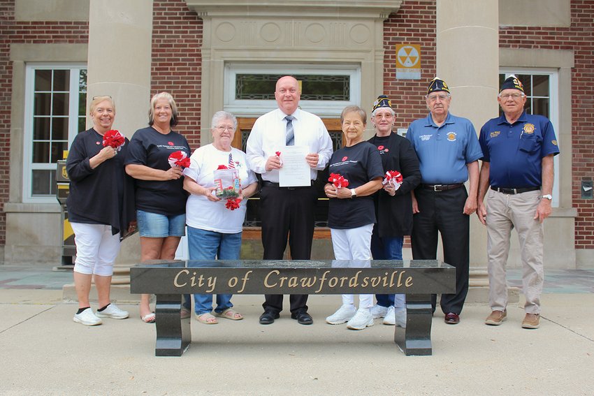 A host of Legion and Legion Auxiliary members from Crawfordsville Post 72 join Mayor Todd Barton, center, in the reading of the proclamation of May as Memorial Poppy Awareness Month, including Cindy Biddle, from left, Kristi Byers, Rosemary Hutchinson, Auxiliary President Carol Roberts, Bonita Clement, Linn Hutchinson and Dale Wilson. The purpose of National Poppy Day, officially dedicated by the U.S. in 1921 following World War I, is to honor all veterans of the armed forces, and their families, who have made the ultimate sacrifice for the unique freedoms Americans enjoy daily.