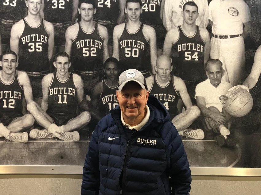 Dick Haslam stands in front of the picture of the 1961-62 Butler basketball team that he was captain of. The Bulldogs won 22 games and appeared in the NCAA Tournament for the first time in school history. Haslam is pictured wearing No. 11.