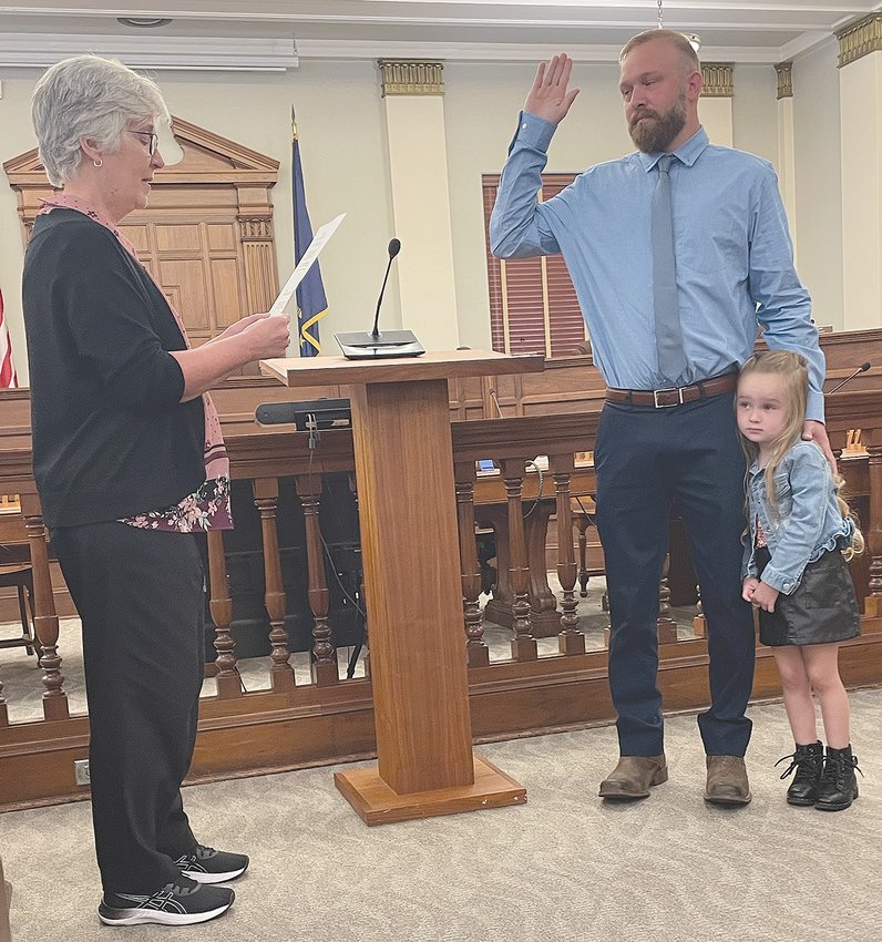 Crawfordsville City Clerk-Treasurer Terri Gadd, left, administers the oath Wednesday to Corey Koontz, making him the city's newest police officer. His daughter, Willow, age 4, accompanies him during the swearing-in ceremony in the council chambers of the City Building.