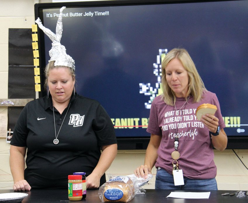 Making a peanut butter and jelly sandwich may seem simple since we have all completed the task many times. How would you tell an &ldquo;alien&rdquo; how to make a sandwich? That was the question posed to science students in Lainey McCrory&rsquo;s seventh grade classes at Parke Heritage Middle School. Using the directions given to them, the &ldquo;alien&rdquo; volunteers attempted to make a sandwich. The sandwiches varied greatly as the aliens followed each step as written. Students in the class quickly realized that when giving instructions detailed steps are required to complete the task. Serving as the alien volunteers were McCrory, Lisa Wrightsman, Brianne Shields and Tyler Milner. This assignment was to reinforce to the students how important it is to read and follow directions, which is essential for science labs. This exercise was also valuable practice as the students are currently creating their own science experiment and writing out their own experiment procedures. Pictured are Parke Heritage Middle School principal Wrightsman and counselor Shields as they prepare to make a peanut butter and jelly sandwich.