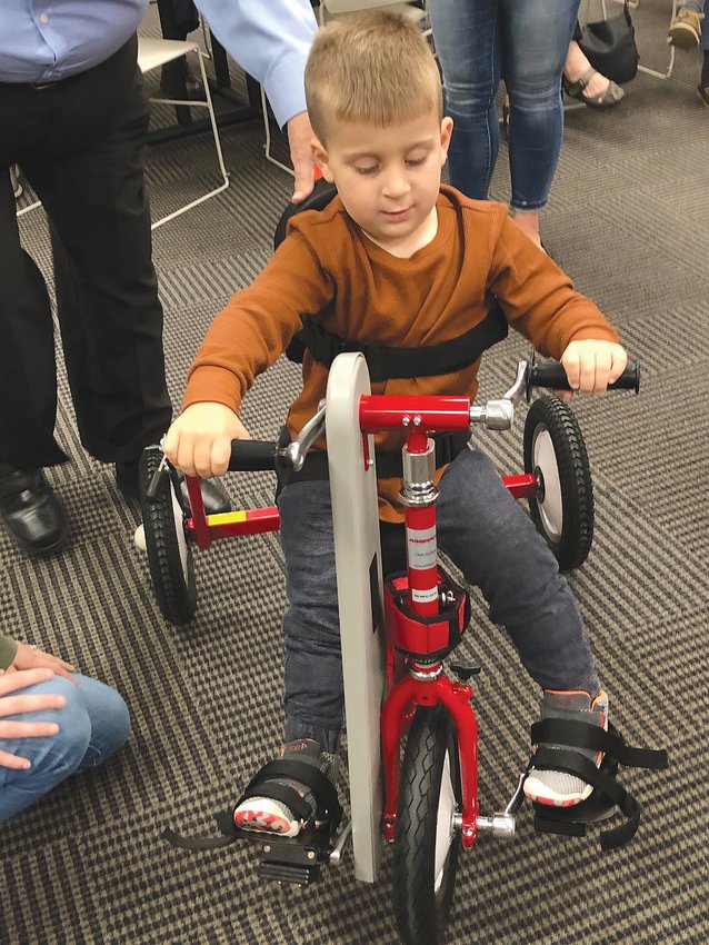 Kyson Shidler takes a ride on his new adaptive tricycle at Thursday&rsquo;s Kiwanis meeting.
