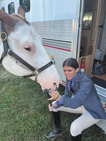 Chelsea Veatch, a 10-year 4-Her, prepares her horse for the English competition Friday at the fairgrounds.