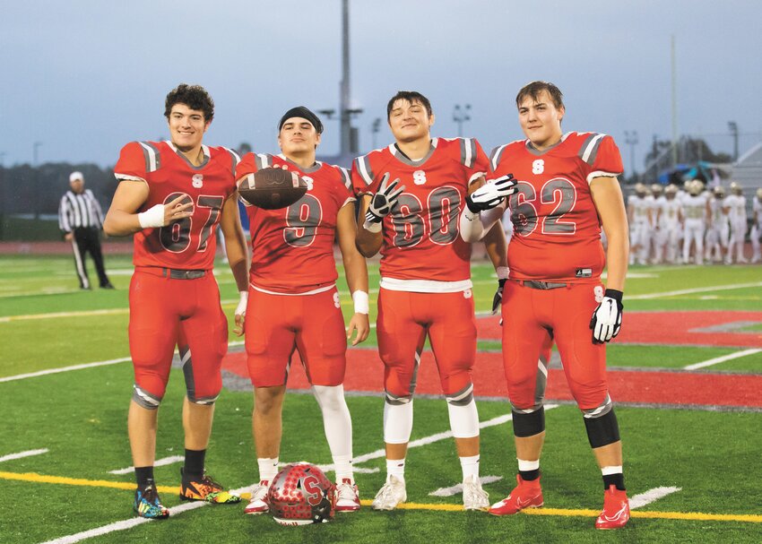 Southmont seniors Waylon Gomez (67), Kasey Line (60), and Will Cody (62) join Wyatt Woodall (No. 9) on senior night as Woodall was presented with a game ball for reaching 3,000 career rushing yards.