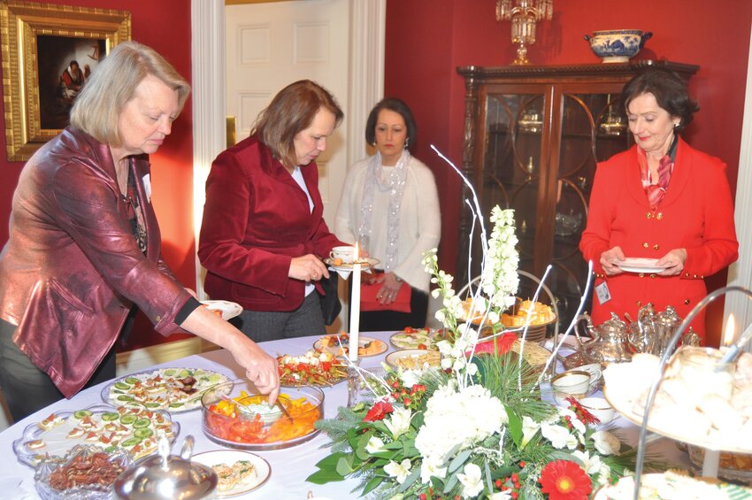 Guests fill their plates at the Elston Homestead during the annual Holiday Tea and Fashion Show.