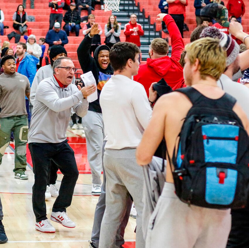 Wabash men's basketball coach Kyle Brumett applauds the Chadwick Crazies for their support during Wabash's 68-63 win over Wittenberg on Saturday.