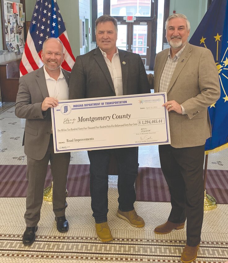 Montgomery County Commissioner John Frey, center, is pictured with INDOT Commissioner Mike Smith, left, and Gov. Eric Holcomb after the county received $1.29M in state grant funds from the Community Crossings Matching Grant program. Money will be used to pave Nucor Road and other neighborhood roads.
