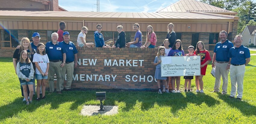 Student council members at New Market Elementary presented a check worth more than $1,000 on Monday to organizers of the Veterans Memorial Park.