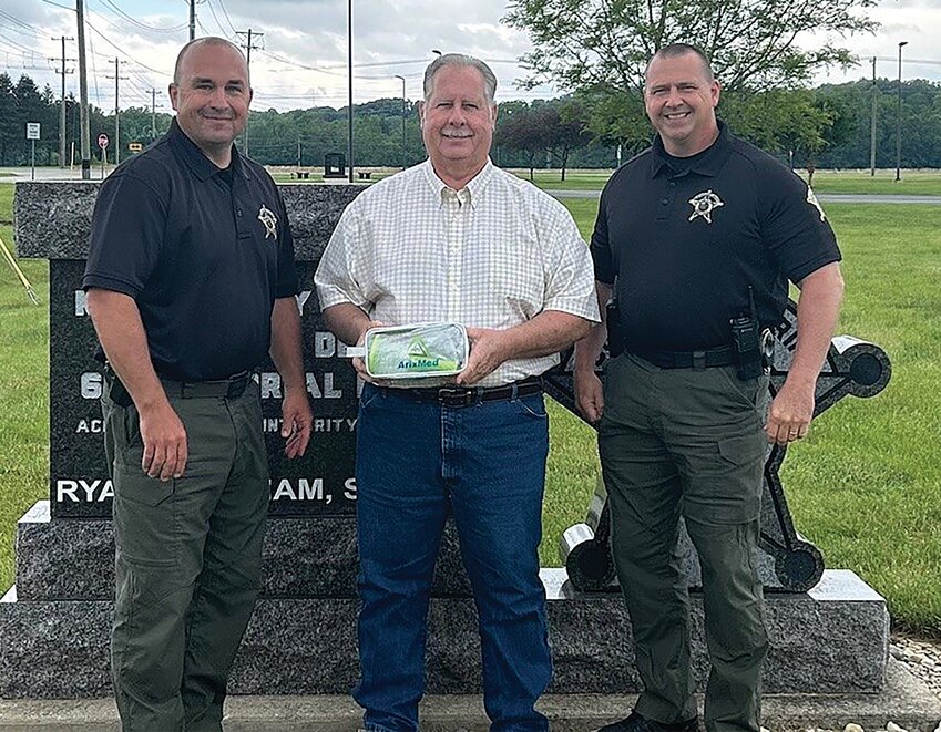Curt Hudson, center, and his wife, Cindy, recently donated ArixMed devices to deputies with the Montgomery County Sheriff&rsquo;s Office. Hudson is pictured, with Sheriff Ryan Needham, left, and Chief Deputy Matt McCarty.