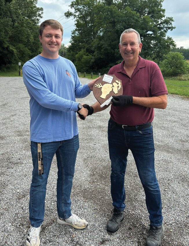 Jerry Whipkey, right, receives a volunteer award from Sam Lovold for his efforts to eradicate invasive plants at the Sugar Creek Nature Park.
