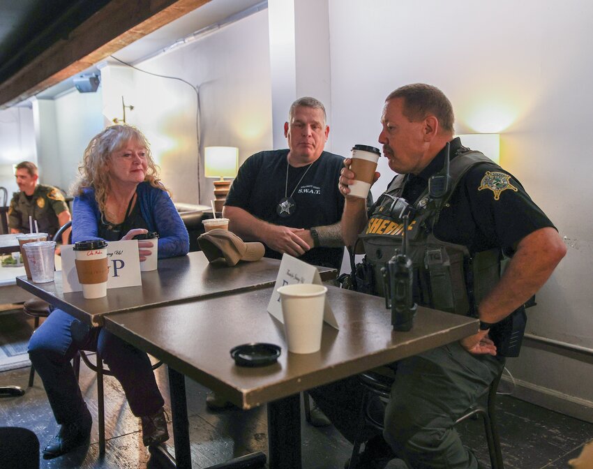 Hayley Jarman/Journal Review
Deputy Todd Walsh, center, and Deputy Scott Teal visit with Sherry Klepfer during Coffee with a Cop at The Joshua Cup on Wednesday.