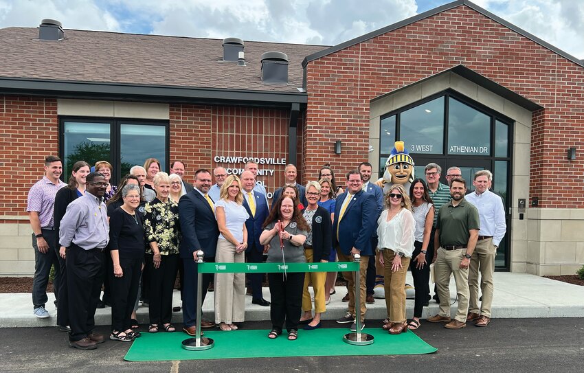 Crawfordsville Community School Corporation administrators, staff, board of school trustees, project partners and representative from the Crawfordsville-Montgomery County Chamber of Commerce gather Tuesday to cut the ceremonial ribbon at the newly constructed administration building. The new building at 3 Athenian Drive is located on the south side of the athletic parking lot at Crawfordsville High School. The 6,200 square foot building provides office space for the superintendent, assistant superintendent, curriculum director, food service director, accounting and payroll, the corporation treasurer and receptionist. Additionally, the building includes a lobby, board room, large conference room, kitchenette and storage space. Kettelhut Construction of Lafayette was awarded the contract for the $3.8 million project, which began in April of 2024.
