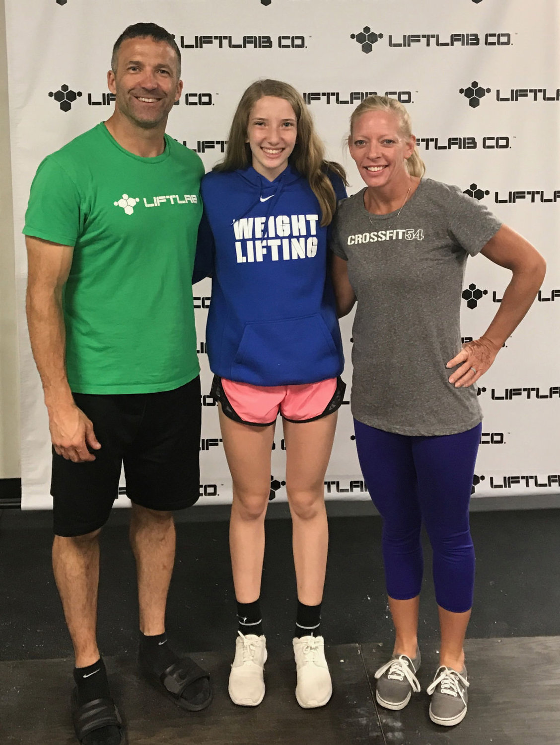 Dori, 13, center, poses with her parents, Jake and Samantha Fredrick at the Lift Lab, Indianapolis.