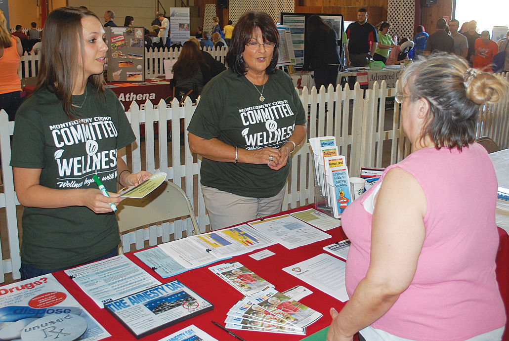 Volunteers at the Montgomery County Health Department Booth pass out information to an attendee at Tuesday's Montgomery County Health Forum.