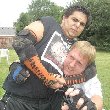 CRAIG MONTOYA of Ultimate Backyard Wrestling rips a headlock around the neck of Brandon Delp as they practice for their upcoming Aug. 10 event.