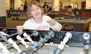 Kaiglynn Harvey laughs after missing the ball while playing a game of Foosball with a friend at the Crawfordsville Boys and Girls Club.
