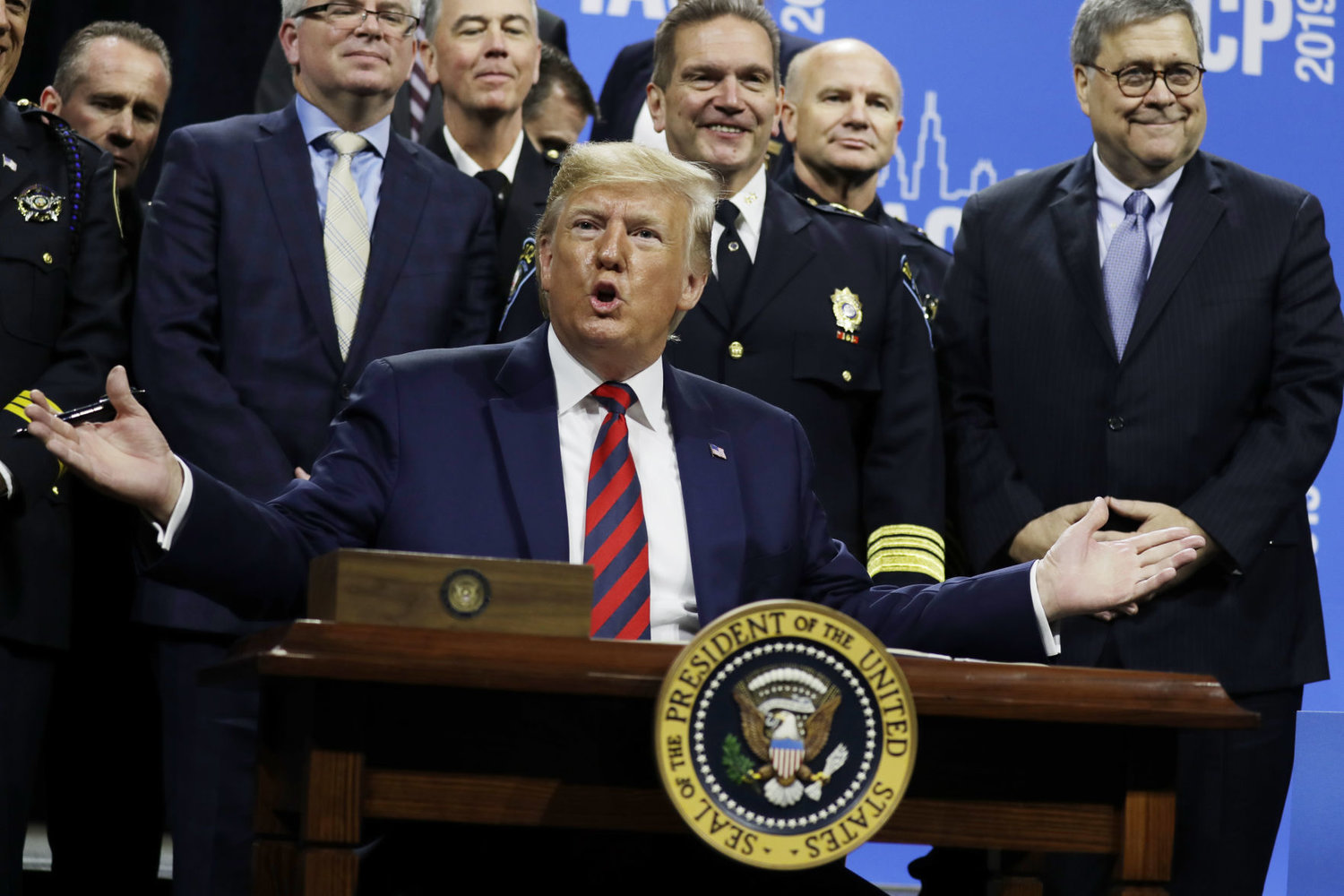 President Donald Trump signs an executive order during the International Association of Chiefs of Police Annual Conference and Exposition, at the McCormick Place Convention Center on Monday, Oct. 28, 2019, in Chicago.