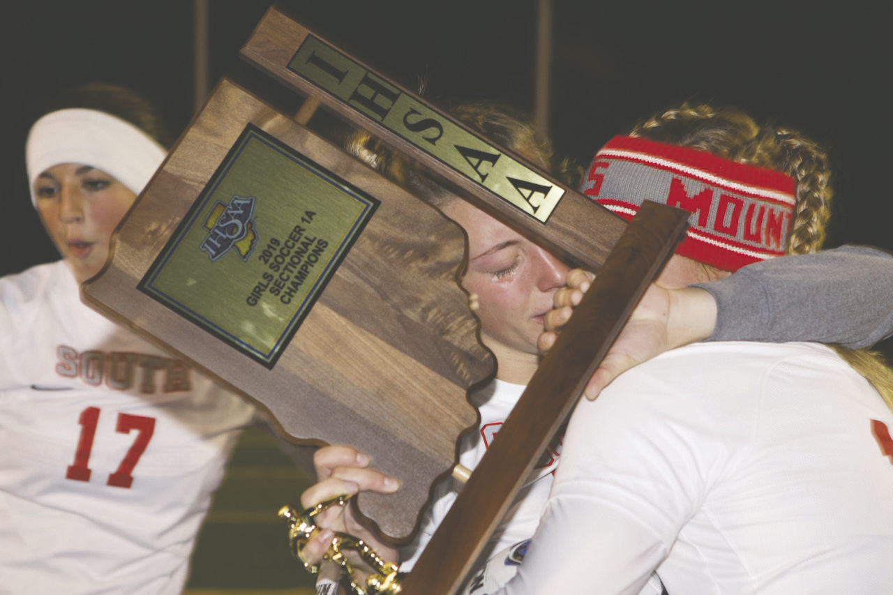 Senior Lexie Odum sheds tears of joy as she clings to the sectional championship trophy and a teammate following Southmont's 1-0 sectional title win over North Putnam.