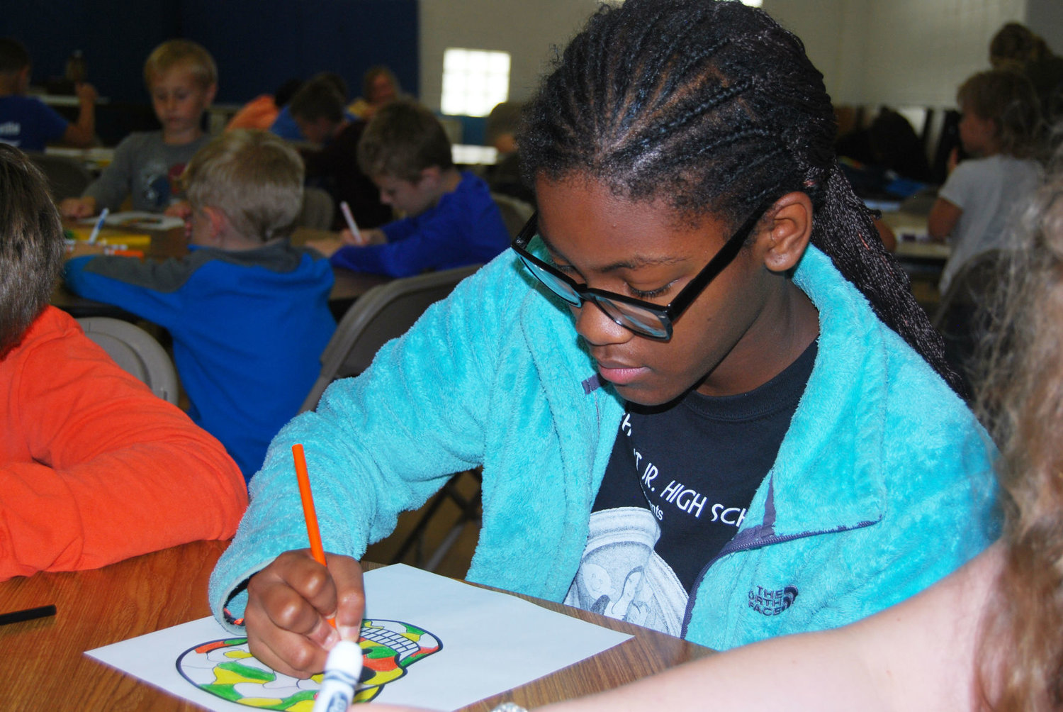 Shaahia Burks, 14, colors a picture Monday at the Boys &amp; Girls Club of Montgomery County. Themed events for the camp include S.T.E.M., a picnic, Kid Olympics and a costume party.