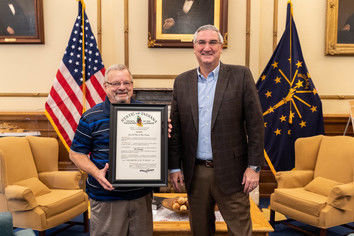 Whiting native Ed Lampa, left, holds his Sagamore of the Wabash award presented by Gov. Eric Holcomb in the governor's Statehouse office. Lampa is retiring after 33 years of state government service, including his unique duty of operating the teleprompter machine during the annual "State of the State" address for Indiana's three most recent governors.