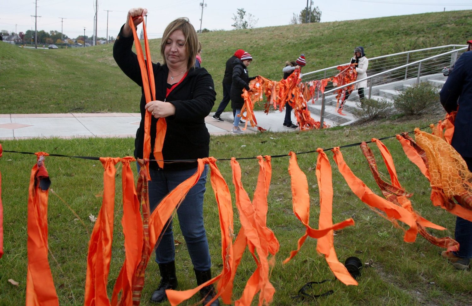 Gidget Griffin, of Michigan City, attaches orange strips to build a chain as a memorial to lives lost to gun violence prior to Saturday’s Moms Demand Action march from Hammond to Chicago. Residents of Indiana and Illinois took part in the march to promote gun safety and related legislation.