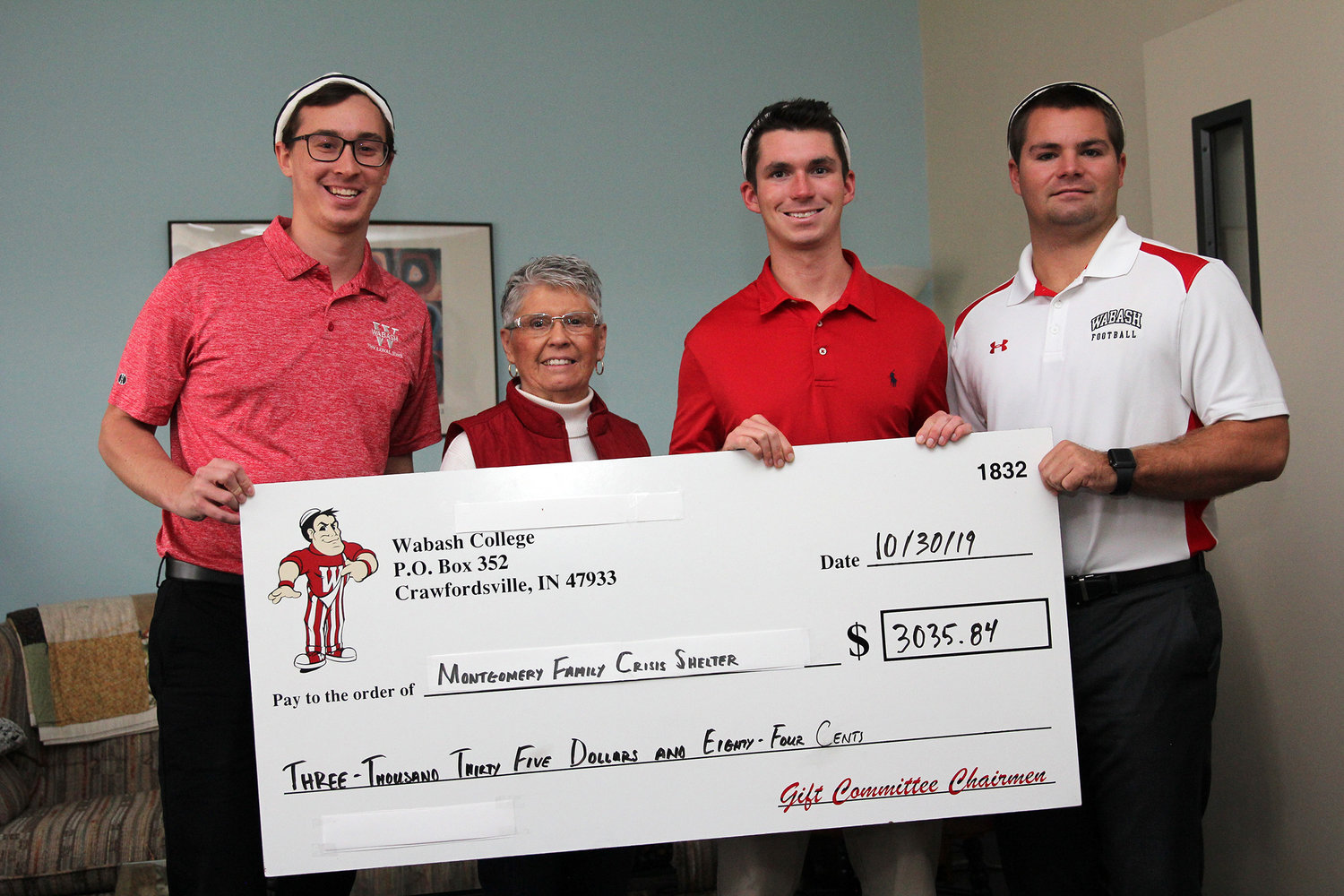 Wabash College's Sphinx Club presented a more than $3,035 donation to the Montgomery County Family Crisis Shelter. The funds were collected during Homecoming weekend. Pictured from left are senior Clark Tinder; Sharon Strasburger, Montgomery County Family Crisis Shelter administrative assistant; senior Matt Fagt; and senior Charlie Brewer. “This donation is wonderful,"  Strasburger said. "We’re low on funds right now because grant money is coming in more slowly than in previous years. This will do a lot for our shelter.” Tinder said, “It’s part of our mission to live humanely. We see the shelter as doing good work, so it’s a meaningful way to put money back into the community and provide some immediate support.”