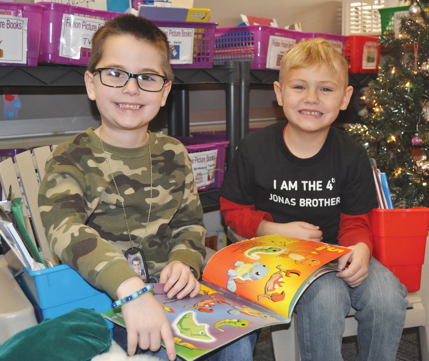 Caleb Archer, left, and Hank West read a book about Pokemon.