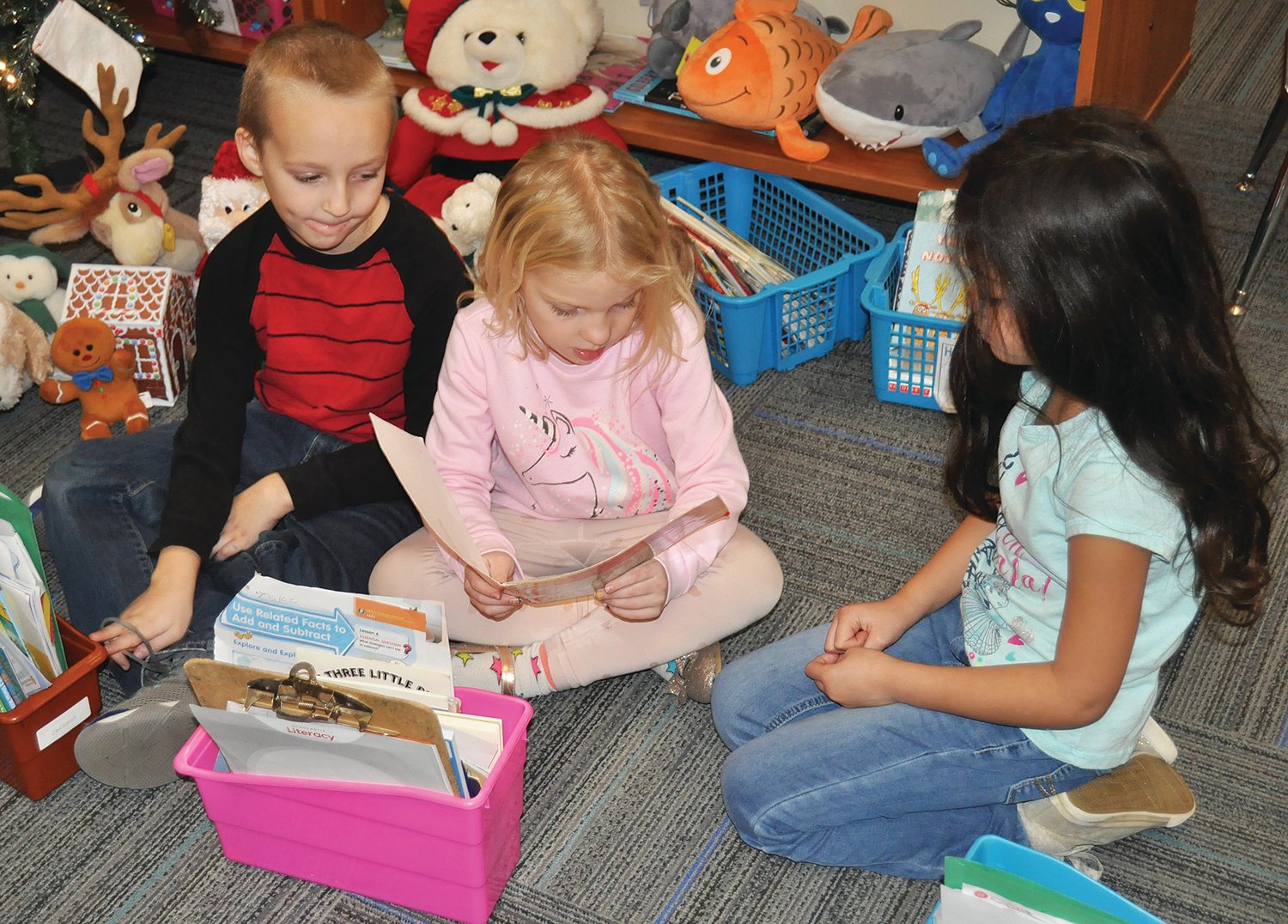 Jacson Kelso, Aynslee Campbell and Sariah Toves share a book together.