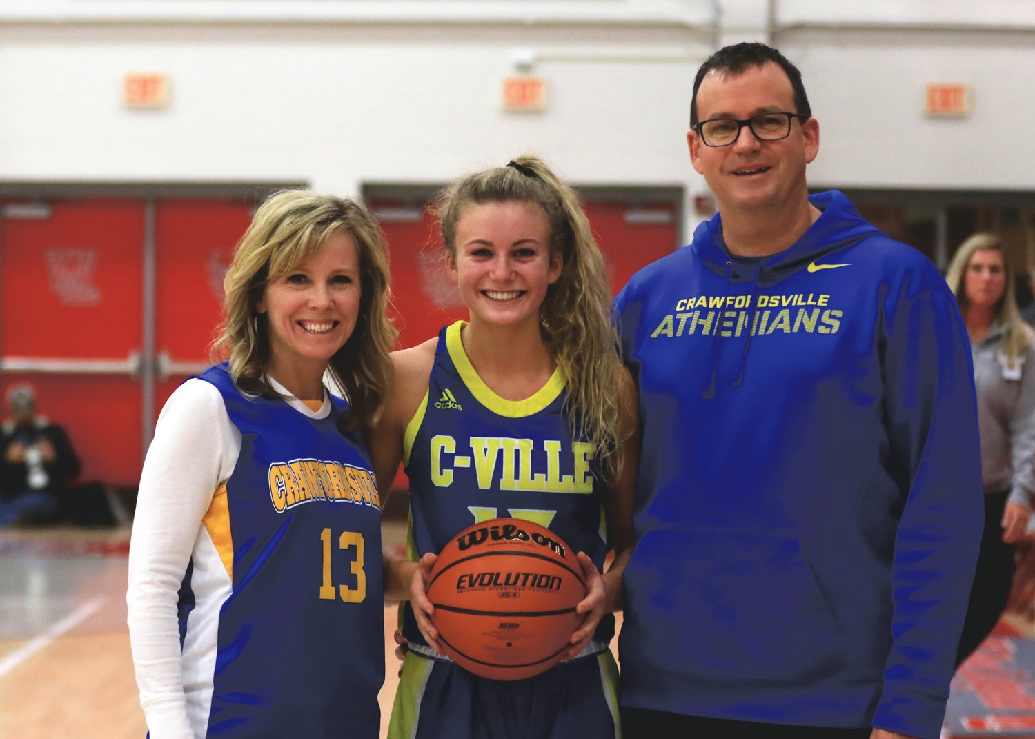 Crawfordsville's Lauren Kellerman stands alongside her parents, Kevin and Holly Kellerman, with a game ball to celebrate her 1,000th point.