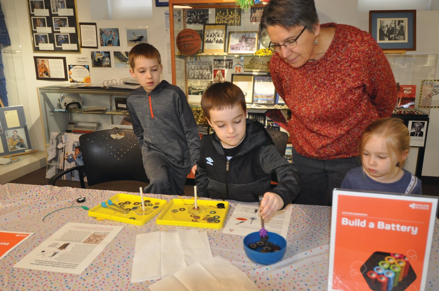 Levi Fowler, center left, builds a battery as Luka Fowler, Karen Thada and Mirium Fowler watch Friday at the Carnegie Museum of Montgomery County. The project was part of the winter break drop-in science activities, which continue Wednesday-Saturday through Jan. 4. The Carnegie will be closed on New Year's Eve and New Year's Day.