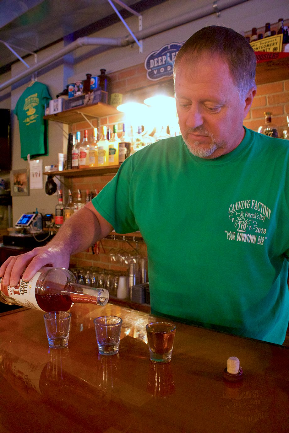 Brett Cating, owner of The Canning Factory Bar & Grill in Ladoga, practices his pouring technique Wednesday ahead of a speakeasy transformation set to take place Friday and Saturday.