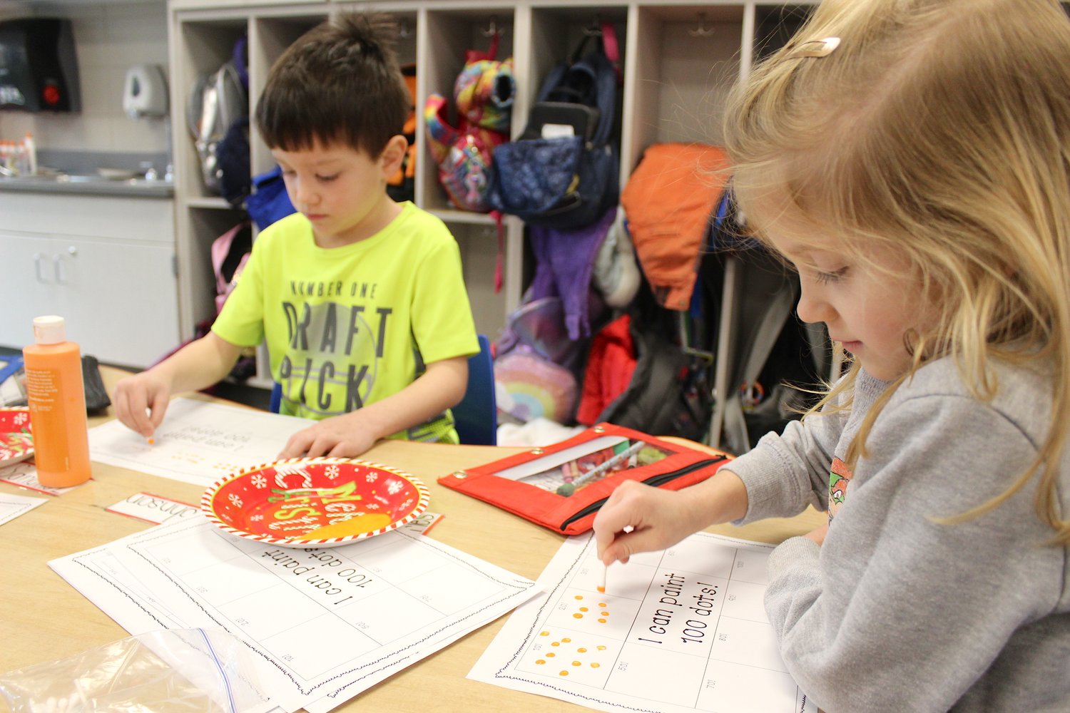 Painting 100 dots, 10 at a time, are Alex Johnson and Caitlin Jeffries during their 100th day of school.