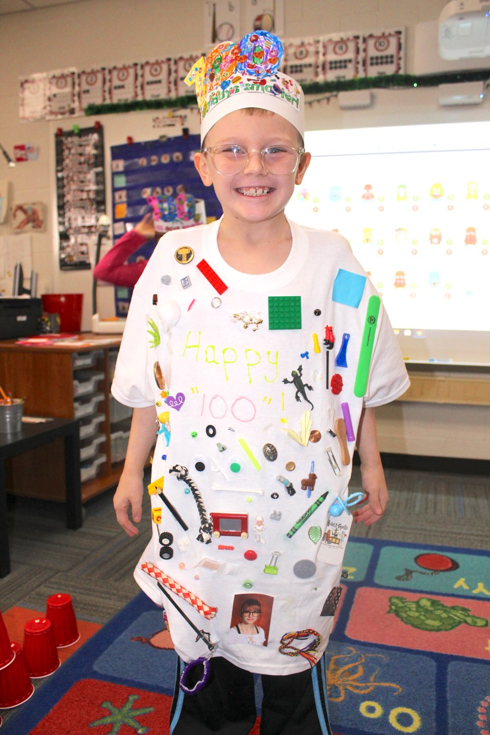Nathanial Fosdick-Stingley, 7, shows off his school spirit by wearing a shirt with 100 items attached Wednesday at Hose Elementary.
