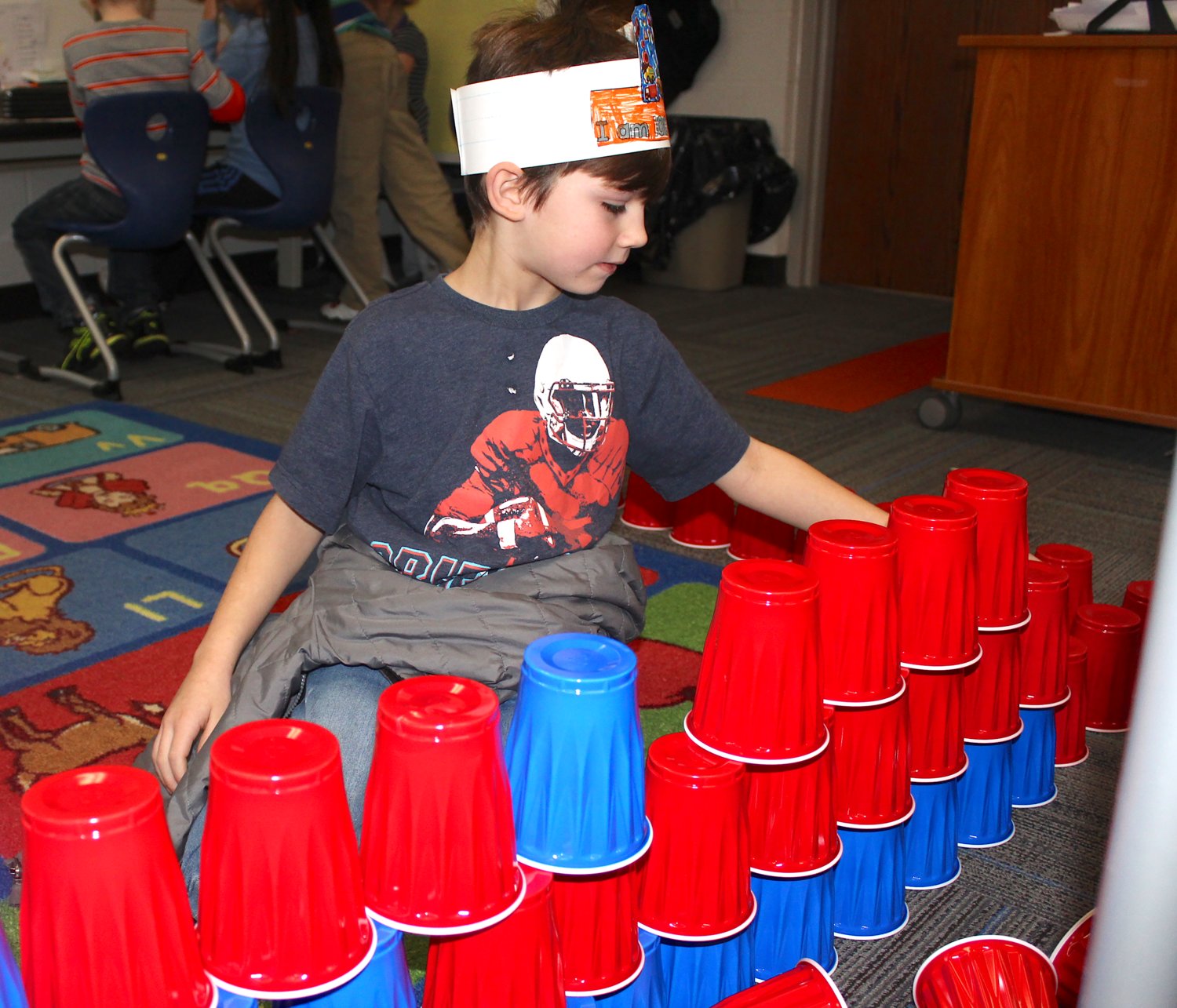 James Brown, 7, first grader at Hose Elementary, stacks 100 cups into a pyramid Wednesday for his 100th day of the 2019-20 school year.