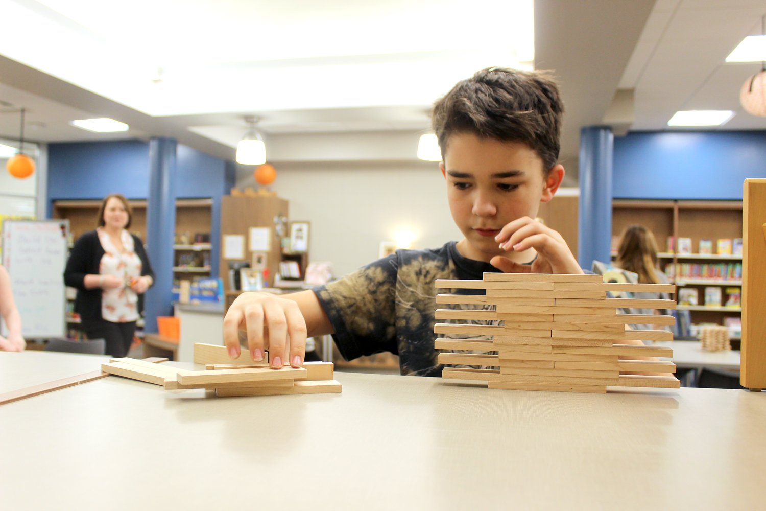 Connor Laws, 10, begins building a Keva-plank tower Thursday at Pleasant Hill. Laws nearly set the day's record with a tower measuring more than 30 inches before its eventual collapse.
