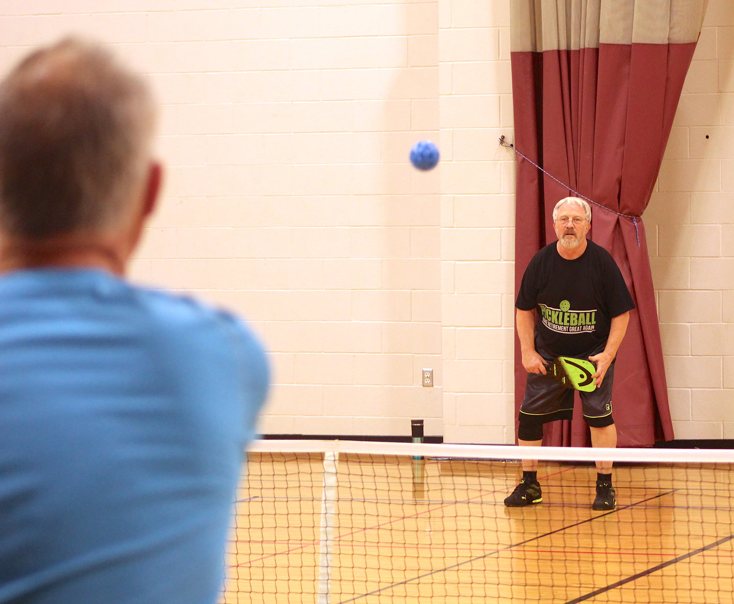 Dave Adams, background, awaits a serve from David Booker on Wednesday during Open Pickleball hours at the Crawfordsville Community Center.