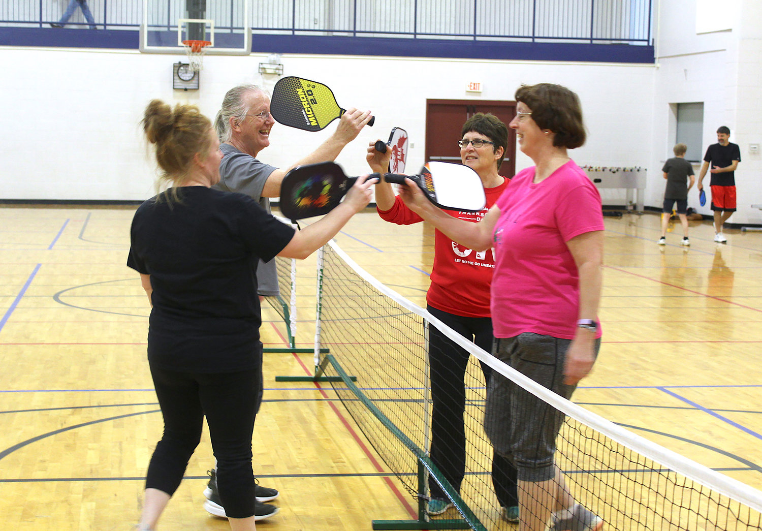 Pickleball enthusiasts Dominique Fruits, from left, Larry Clarke, Vicki Deer and Jean Kyle congratulate one another after a successful game of Pickleball at the Crawfordsville Parks and Recreation building.