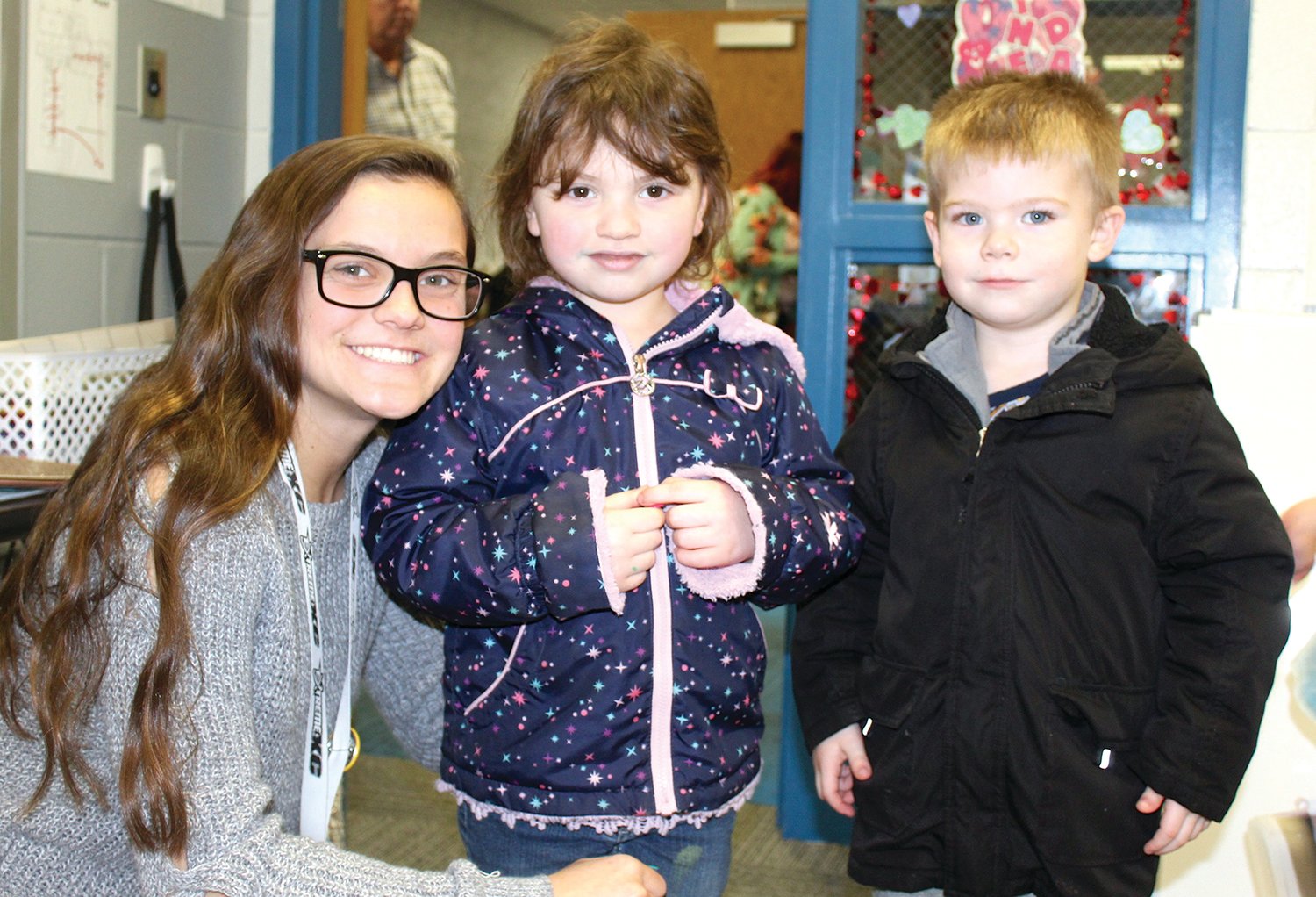 Little Mountie Preschool Aide Hailey France, from left, and students Stella Hughes and Kasen Jones put on their coats as they prepare to end the day and head home from Walnut Elementary.