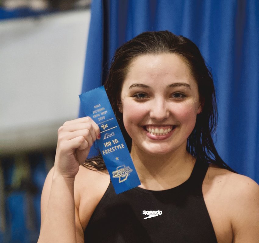 Crawfordsville sophomore Alyx Bannon proudly shows off her blue ribbon after winning the 100 freestyle and punching her ticket to the state finals.