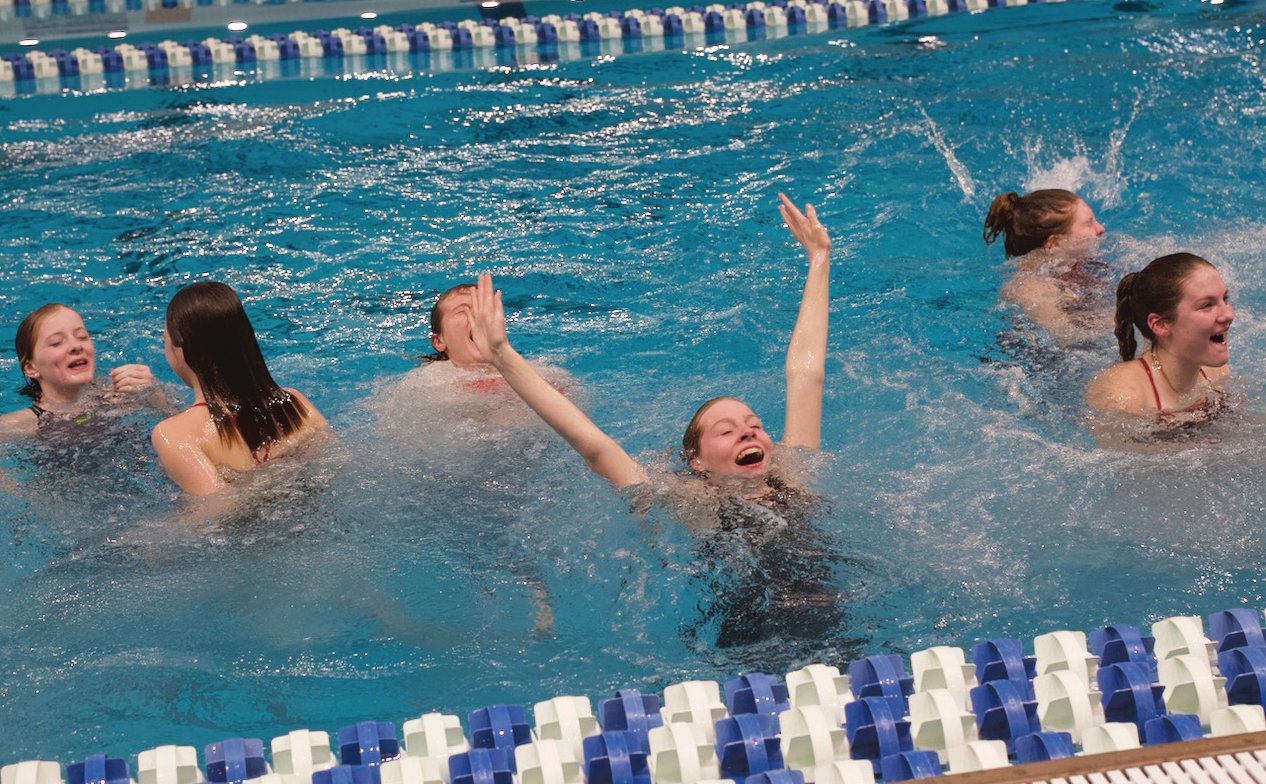 Members of the Mountie swim team celebrate in the pool after the sectional win.