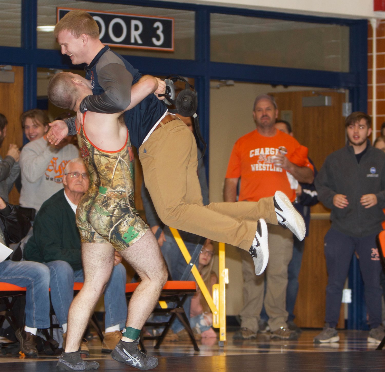 North Montgomery senior Dawson McCloud picks up Charger wrestling coach Bryce McCoy after he punched his ticket to the regional final with come-from-behind win over Carmel's Garrett Sharp.