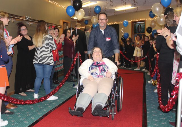 During New Hope Christian Church’s second annual Night to Shine event, sponsored by the Tim Tebow Foundation, Senior Pastor Darrell Portwood helps Sharon McClure along the red carpet entrance on Friday.