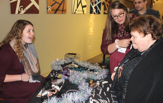 Elyse Thompson and Carlson Sarson, right, hit the hair accessory table Friday at New Hope Christian Church during the Night to Shine event.