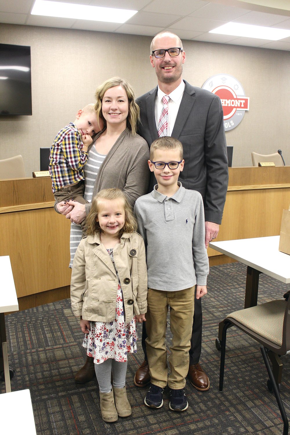 Jesse Burgess, newly hired as principal at Southmont High School, stands tall with his after receiving approval from the Southmont school board Monday. Burgess was accompanied by his family Monday, including his wife Jenna, his six-year-old daughter Cora and sons Caleb, standing, and Knox.
