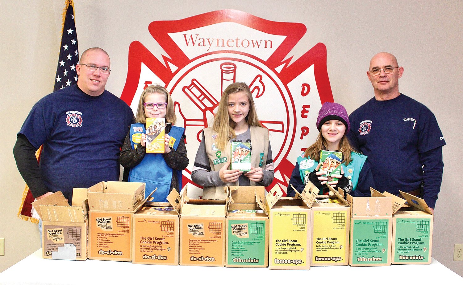 Waynetown Volunteer Firefighter Ryan Clevinger, left, and Fire Chief Phil Pirtle, right, stand with their Girl Scout partners Saturday before delivering $500 of Girl Scout cookies purchased by the department to elderly residents. Scouts riding along in the fire truck were Maiah Rathburn, from left, Lacie Bush and Elizabeth Ellingwood of Troop 57078 out of Crawfordsville.
