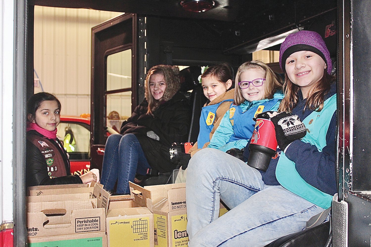 Girl Scouts from multiple troops climb aboard the Waynetown Volunteer Fire Department truck Saturday in Waynetown to deliver cookies to more than 70 residents. They include Jillian Clark, from left, Lacie Bush, Carley Simms, Maiah Rathburn and Elizabeth Ellingwood.