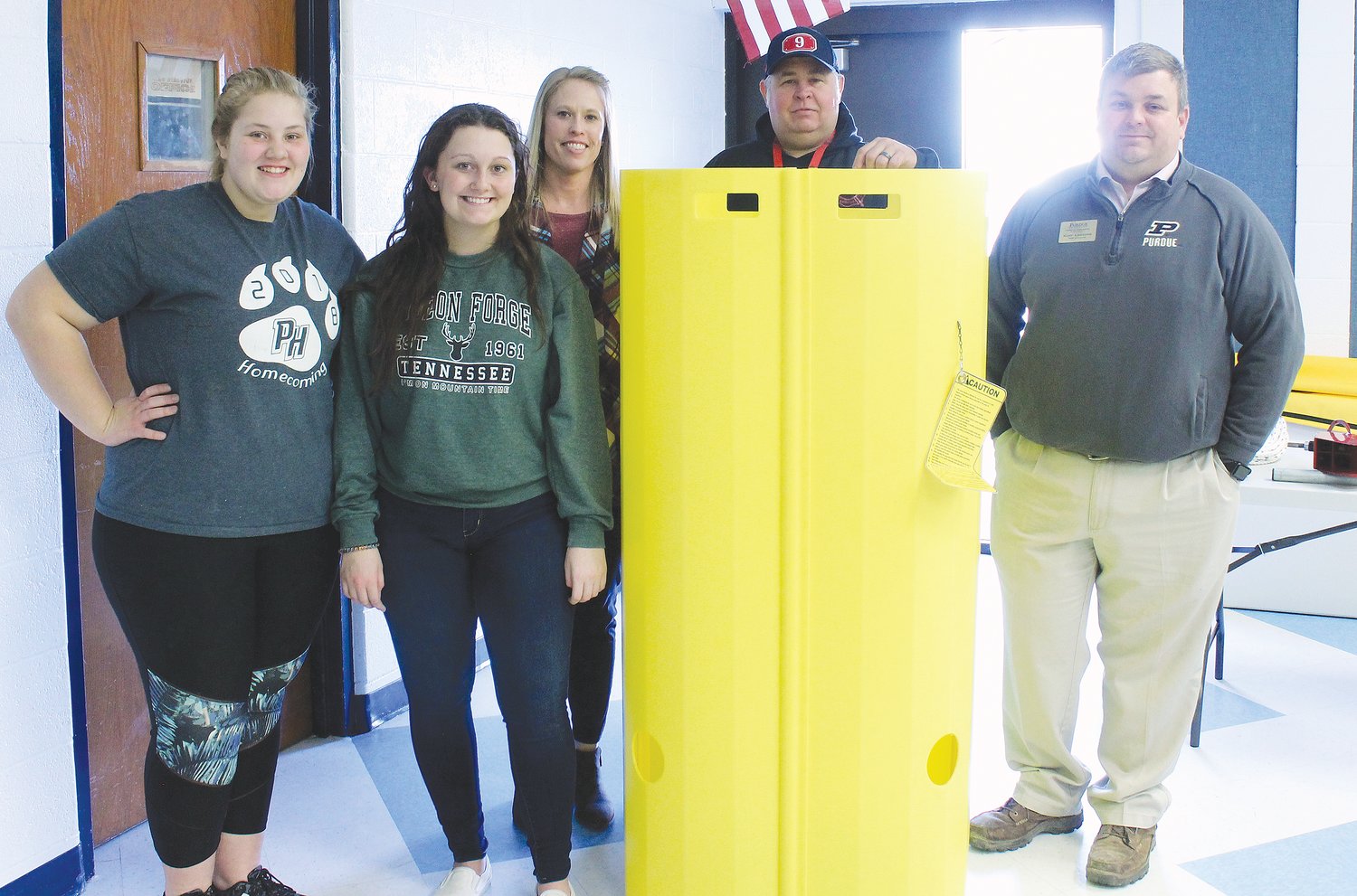 With the grain bin rescue tube used by fire departments are Mandy Girdler, Madison Nelson, Lacy Romig, Jason Games and Kurt Lanzone.