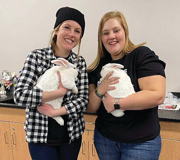 Shannon Witty and Mandy Girdler hold meat rabbits raised as part of an FFA project at Parke Heritage High School.